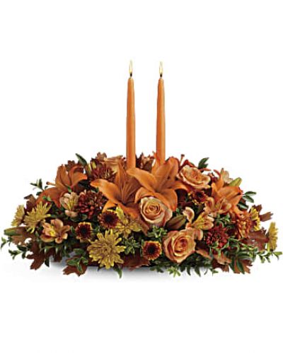 <p>Graciously gather your family around the warm glow and classic autumn colors of this stunning Thanksgiving centerpiece. A lush variety of burnt orange blooms are gathered under a pair of tall, graceful candles - perfect for decorating your Thanksgiving dinner table, entryway or hearth.</p>