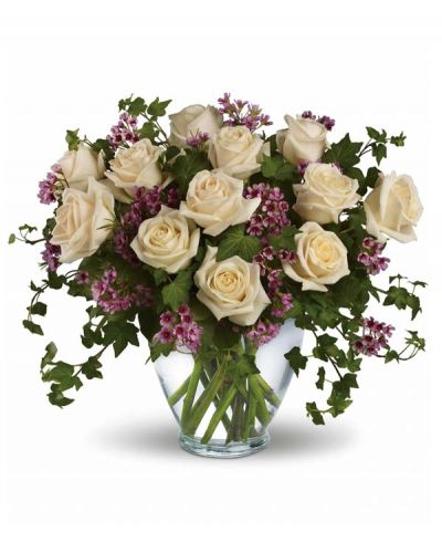 <p>A visual representation of pure romance, a dozen cream roses, lavender waxflower and ivy are perfectly arranged in a serenity glass vase.</p>