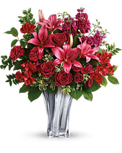 <p>The epitome of romance, this breathtaking bouquet of red roses and pink lilies reaches a new level of luxury thanks to its elegant glass vase with sleek lines.<br />
Red roses, dark red spray roses, dark pink asiatic lilies, red alstroemeria, and burgundy stock are arranged with lemon leaf, huckleberry, and pitta negra.</p>