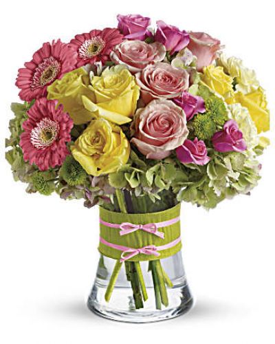 <p>Flowers are always in fashion! Especially this chic mix of pinks, greens and yellows, arranged in a style evoking the English hand-tied bouquet. It’s a stylish surprise for any lucky lady.<br />
Mini pink gerberas, lush green hydrangea, yellow and pink roses, yellow carnations and green button mums are arranged in a clear concave vase that’s trimmed with a chartreuse taffeta ribbon and pink raffia.</p>